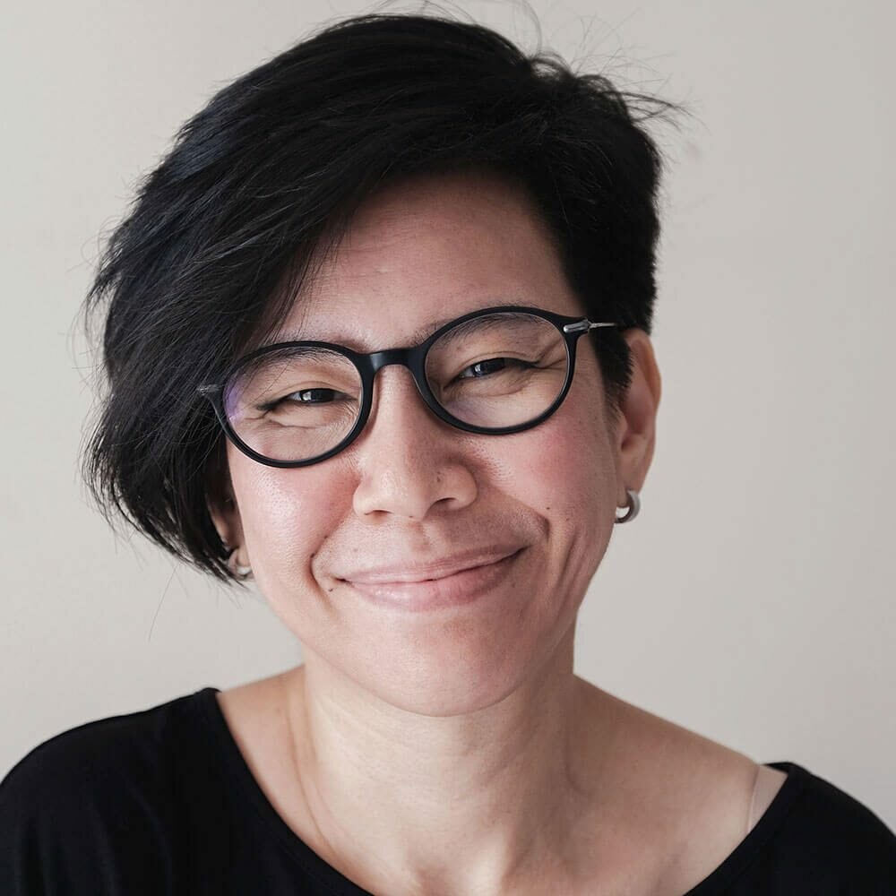 Case 2 Study - Susan Smiling middle-aged caucasian female with black circular glasses